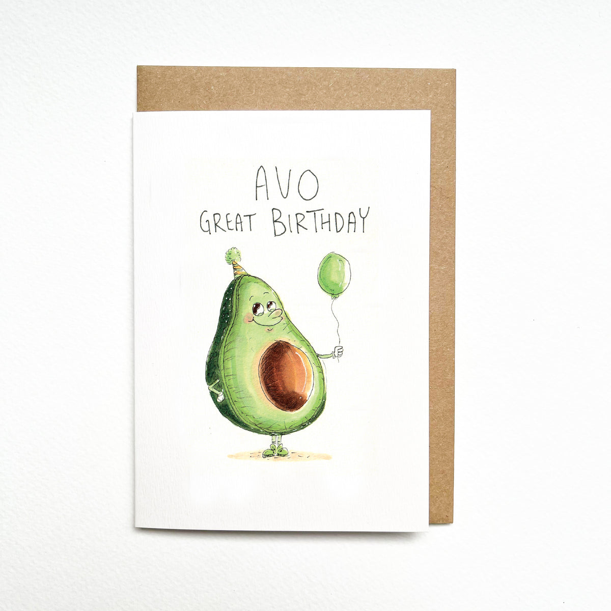 Avo Great Birthday – a smiling avocado holding a balloon and wearing a tiny party hat by Well Drawn Melbourne. Front product photo.